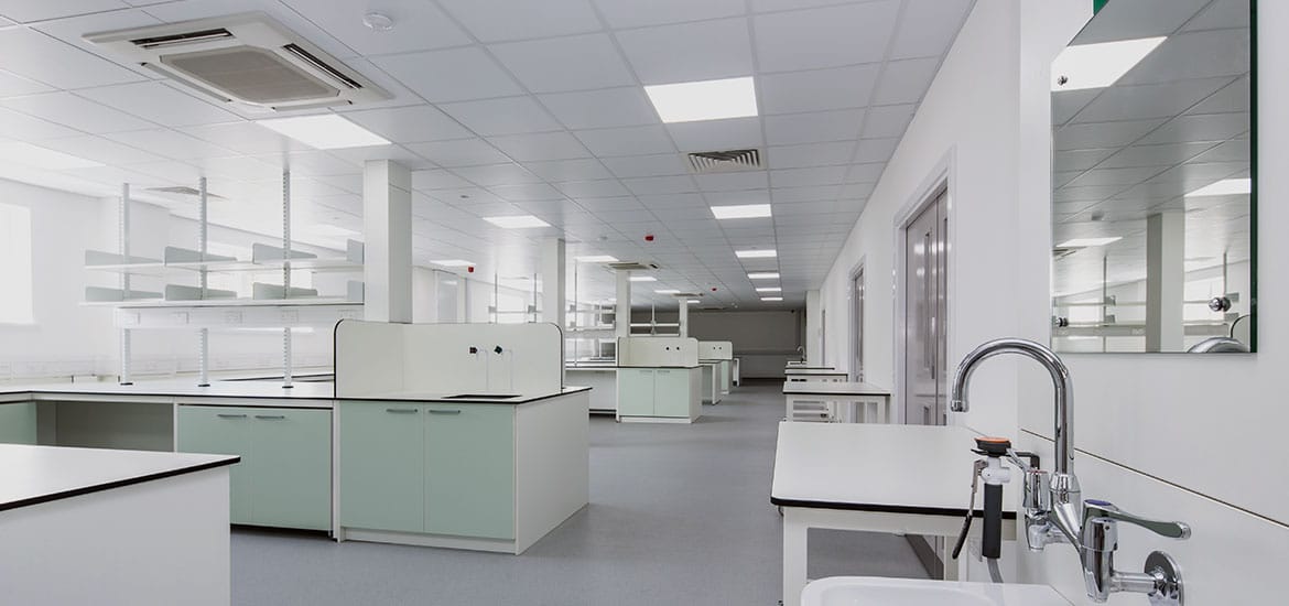 Large science laboratory with green cabinets and sliver taps